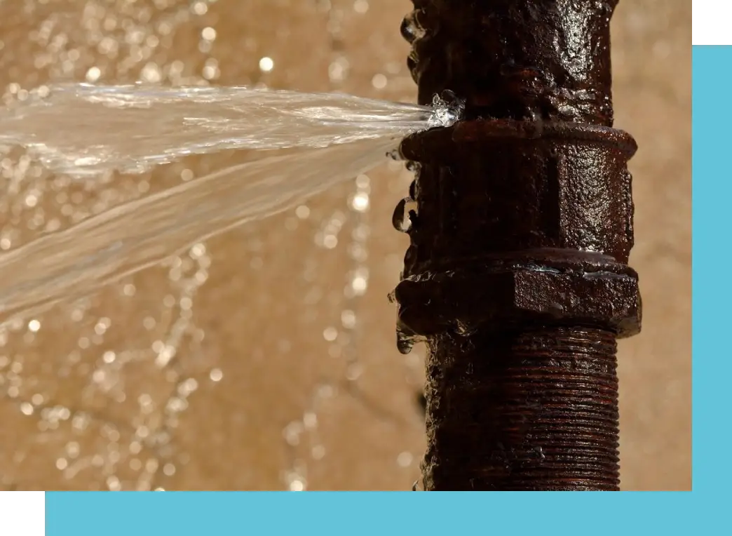 A water main is spraying out of the ground.